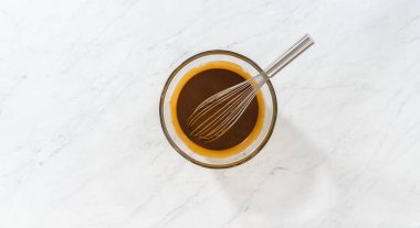 Flat lay. Mixing wet ingredients in a small glass mixing bowl to bake gingerbread bundt cake with caramel filling.