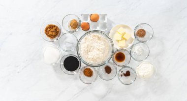 Düz yatıyordu. Bardaktaki ölçülü malzemeler zencefilli kek ve karamel dolgulu kek pişirmek için karıştırılıyor..