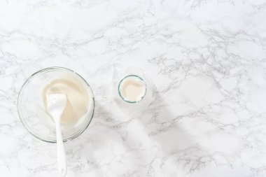 Düz yatıyordu. Şekerli kurabiyeleri süslemek için boru torbalarına ev yapımı kraliyet kreması aktarılıyor..