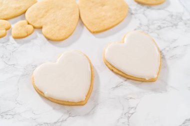 Sevgililer Günü için pembe ve beyaz kraliyet kremalı kalp şeklinde kurabiyeler..