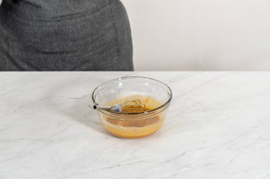 Mixing ingredients with a hand mixer in a small mixing bowl to make the caramel filling for bundt cake.