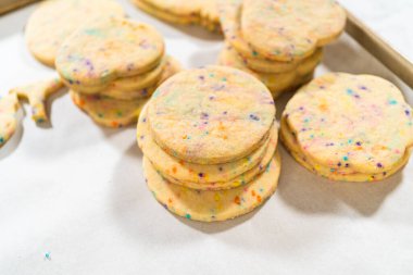 Büyük miktarda şekerli kurabiye düzgünce pişirme tepsisine istiflenmiş, paketlerinin kırsal kahverengi karton kutulara konmasını bekliyor..