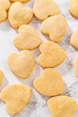 Sevgililer Günü için pembe ve beyaz kraliyet kremalı kalp şeklinde kurabiyeler..