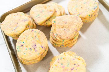 Büyük miktarda şekerli kurabiye düzgünce pişirme tepsisine istiflenmiş, paketlerinin kırsal kahverengi karton kutulara konmasını bekliyor..