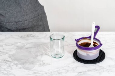 Erimiş çikolatayı, pandaya benzeyen kurabiyeleri dondurmak için boru torbalarına aktarıyorum..