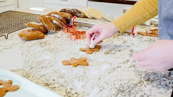 さまざまなお祝いのクッキーカッターを使用して 洗練された大理石のカウンターのローリング生地から魅力的なジンジャーブレッドクッキーを切り出し 現代のキッチンに休日の応援をもたらしました — ストック写真