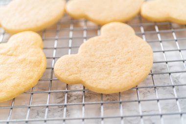 Cooling panda-shaped shortbread cookies on a cooling rack at the kitchen counter.