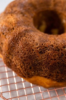 Soğutucu rafı yuvarlamak için taze fırınlanmış havuçlu keki kek kalıbından kaldırıyorum..