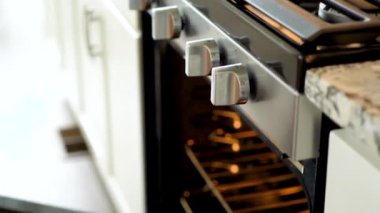 Modern bir mutfak ortamında, genç bir adam şu anda fırında baharatlı gökkuşağı patatesi kızartılarak lezzetli bir yemeğe doğru önemli bir adım atıyor..