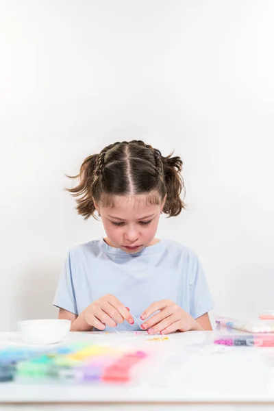 Küçük Kız Parlak Kil Boncuklarla Renkli Bilezikler Yapmaktan Hoşlanıyor — Stok fotoğraf
