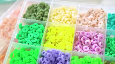 Renklere göre sıralanmış çeşitli kil boncukların yakın plan çekimleri, her boncuğu el yapımı ve mücevher yapımında eşsiz kılan desenleri ve desenleri vurguluyor..