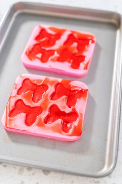 Removing chocolate bows from the silicone molds to make a chocolate pretzel Christmas wreath.