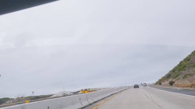 Kederli, bulutlu bir kış gününde, California, Rincon Sahili yakınlarında 101. Otoyol 'da araba sürüyorum..