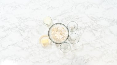 Düz yatıyordu. Bardaktaki ölçülü malzemeler mayasız tarçınlı kek pişirmek için karıştırılmış kaseler..