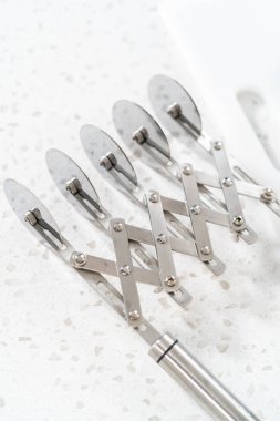 Removing chocolate pistachio fudge from a square cheesecake pan lined with parchment.