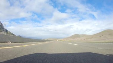 Santa Maria, California, ABD-6 Aralık 2022-Kış gününde San Luis Obispo, Kaliforniya yakınlarındaki ikonik 1. Otoyol boyunca bir araba ilerliyor. Çevresindeki manzara kahverengimsi ve bastırılmış.