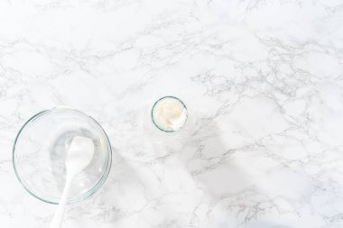 Düz yatıyordu. Şekerli kurabiyeleri süslemek için boru torbalarına ev yapımı kraliyet kreması aktarılıyor..