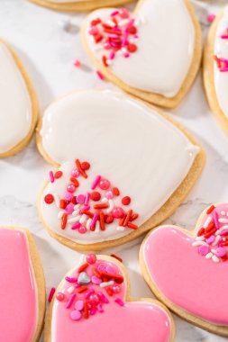 Sevgililer Günü için pembe ve beyaz kraliyet kremalı kalp şeklinde kurabiyeler..