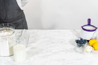 Cam bir kasenin içindeki bileşenleri birleştirmek, bir çırpıcıyla karıştırmak, limonlu-yabanmersinli kek hazırlamak..