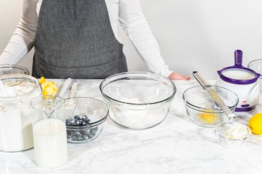 Cam bir kasenin içindeki bileşenleri birleştirmek, bir çırpıcıyla karıştırmak, limonlu-yabanmersinli kek hazırlamak..