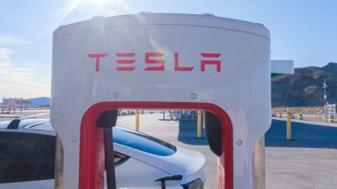 Baker, California, ABD-3 Aralık 2022-Gün boyunca Tesla bir süper şarj istasyonunda yüksek hızlı şarj altyapısını uygun ve verimli bir şekilde kullanan bir Tesla aracı görüldü.