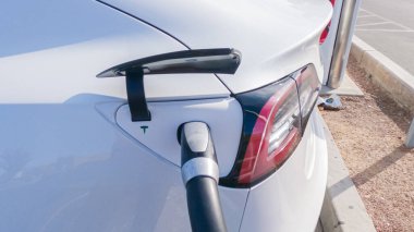 Primm, Nevada, ABD-3 Aralık 2022 - Gün içinde, Tesla süperşarj istasyonunda bir Tesla aracı şarj olurken görüldü, kullanışlı ve verimli olması için yüksek hızlı şarj altyapısını kullandı