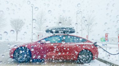 Denver, Colorado, ABD-7 Aralık 2022 Batı Colorado 'ya yapılan kış yolculuğunda bir Tesla elektrikli arabası bir süperşarj istasyonunda durur..