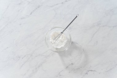 Düz yatıyordu. Toz şeker tozunu hazırlamak için malzemeleri el çırpıcısıyla karıştırıyorum..