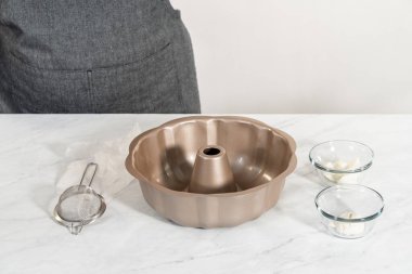 Limonlu kek pişirmek için sebze boyası ve un ile yağlı metal kek tepsisi..