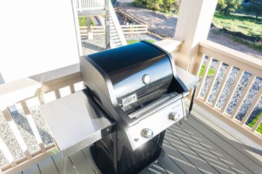 Denver, Colorado, ABD-Haziran 3, 2023-Webers gösterişli, kapalı iki ocaklı ızgara, düşünceli bir şekilde bir banliyö evinin balkonuna yerleştirilmiş, enfes bir açık hava pişirme deneyimi için hazır.