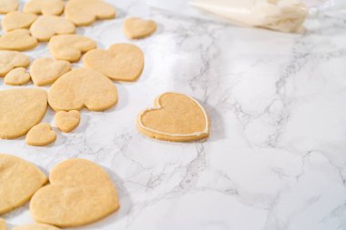 Sevgililer Günü için pembe ve beyaz kraliyet kremalı kalp şeklinde kurabiyeler..