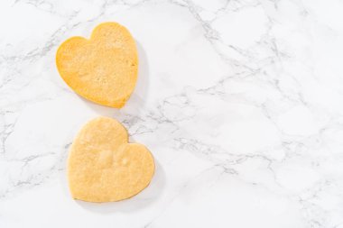 Sevgililer Günü için pembe ve beyaz kraliyet kremalı kalp şeklinde kurabiyeler..