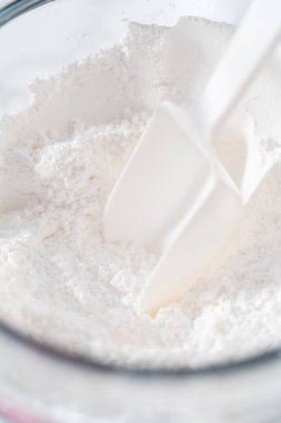 Ev yapımı kraliyet kreması yapmak için büyük bir cam karıştırma kabında malzemeleri karıştırıyorum..