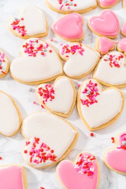 Sevgililer Günü için pembe ve beyaz kraliyet kremalı kalp şeklinde kurabiyeler..