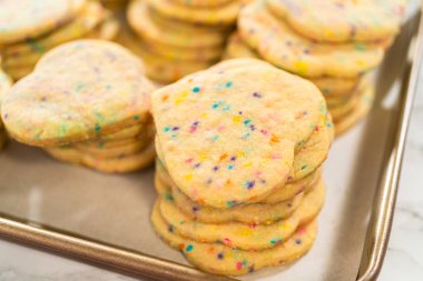 Büyük miktarda şekerli kurabiye düzgünce pişirme tepsisine istiflenmiş, paketlerinin kırsal kahverengi karton kutulara konmasını bekliyor..