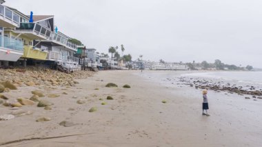 Los Angeles, California, ABD-4 Aralık 2022-POV-Yürürken Miramar Sahili, California kıyılarında bulutlu kış gökyüzü sakin ve yansıtıcı bir atmosfer yaratır..