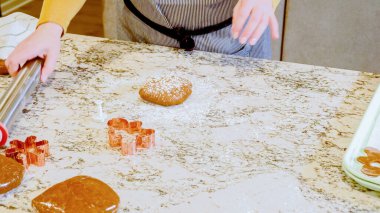 Modern bir mutfaktaki zarif mermer tezgahın üzerine zencefilli kurabiye hamuru sermek için ayarlanabilir bir merdane kullanmak, bayram pişirme şenliğine hazırlanmak....