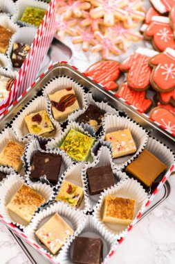 Noel yemeği için ev yapımı şekerleme ve zencefilli kurabiye paketlerini teneke kutulara koyuyoruz..