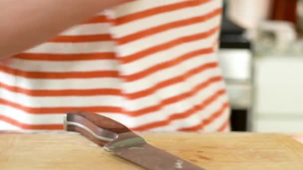 在现代厨房的氛围中 一个年轻人正在准备晚饭 他目前的活动是在一块木板上把小的彩虹土豆切成两半 — 图库视频影像