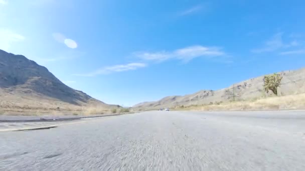 ネバダ州からカリフォルニア州へのロードトリップで 日中のハイウェイ15を運転すると 風光明媚な景色と州間のエキサイティングな旅を提供しています — ストック動画