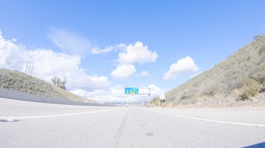 Kış günü San Luis Obispo, Kaliforniya yakınlarındaki ikonik otoyol 101 boyunca bir araba gider. Çevresindeki manzara kahverengimsi ve bastırılmış, dalgalı tepeler ve kıyı şeritleriyle