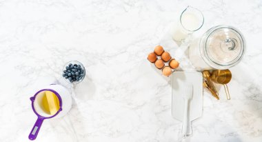 Düz yatıyordu. Cam kasenin içindeki malzemeleri birleştirmek, lezzetli bir vanilyalı kek hazırlamak için ustalıkla çırpmak..