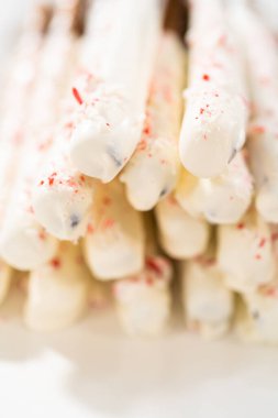 Beyaz servis tabağında ev yapımı çikolata kaplı çubuk kraker yığını..