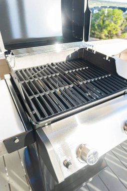 Gösterişli, açık kapaklı, çift ocaklı ızgara kullanıma hazır, banliyödeki bir evin balkonunda konumlandırılmış, nefis bir yemek pişirme deneyimi vaat ediyor..