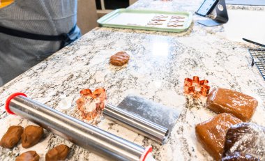 Çağdaş beyaz bir mutfakta zencefilli kurabiye hamuru ustalıkla sarılır ve nefis bir tatil ziyafeti için zemin hazırlar..