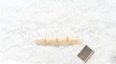 Düz yatıyordu. Tarçın ile doldurulmuş rulo ekmek hamuru ve daha küçük rulolara doğranmış fındıklar tarçınsız kek pişirmek için..