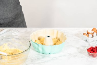 Kek tepsisini yağladıktan sonra, onu kek hamuru ve lezzetli ahududu kekiyle doldurma zamanı geldi..