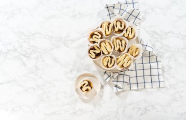 Düz yatıyordu. Taze pişmiş mayasız tarçınsız çörekler tarçın dolgulu ve doğranmış cevizli..