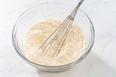 Kuru malzemelerle bardaktaki çırpıcıyı karıştırıp limonlu yaban mersinli kek yapıyorum..