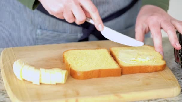 近代的なホワイトキッチンでは バターバナナとブリオッシュパンはおいしいグリルピーナッツバターバナナサンドイッチを作るために準備されています — ストック動画